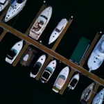 An overhead view of various boats neatly docked in a marina, prompting consideration of What amenities do houseboats offer.